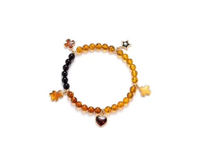 Bransoletka z bursztynu w ciepłych odcieniach, ozdobiona pozłacanymi zawieszkami, elegancka i stylowa